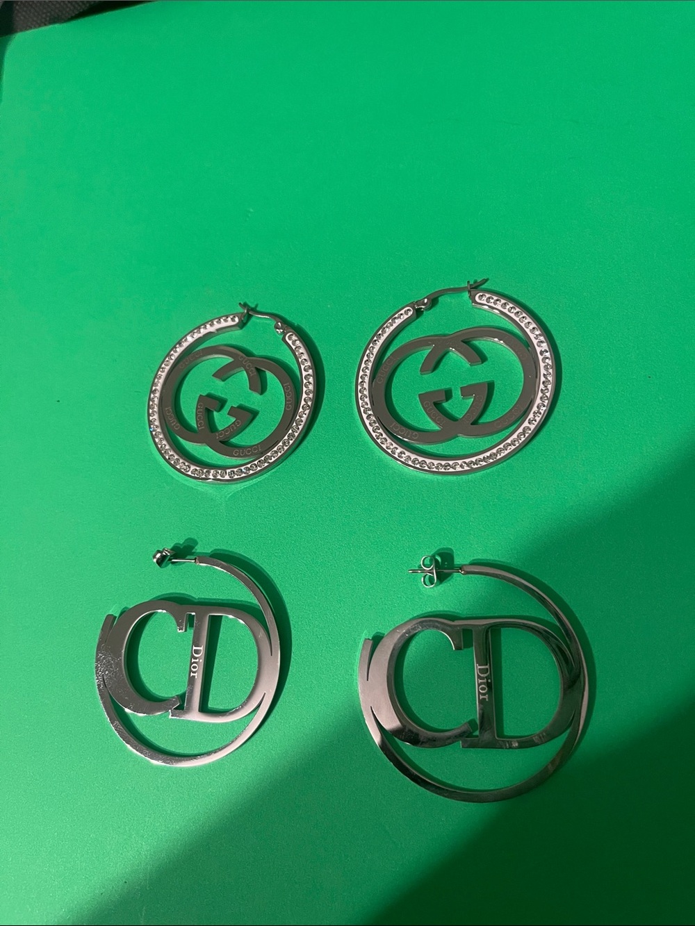 Stainless steel Silver hoop Earrings set on Green Background